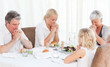 Pretty family praying at the table