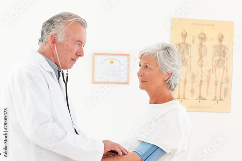 Photo: Doctor taking the blood pressure of his patient Doctor taking the blood pressure of his patient