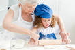 Photo: A little girl baking with her grandmother A little girl baking with her grandmother