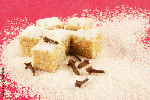 Photo: Blocks of sugar and spiciness on a red background Blocks of sugar and spiciness on a red background