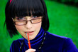 young thinking woman in glasses with pen
