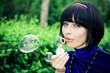 young female makes soap bubbles