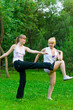 two women doing yoga in park