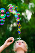 Young beautiful woman blowing soap bubbles