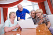 Seniors watching photos via laptop