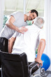 Volunteer helping old man to walk