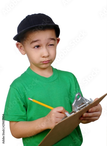 Foto: Boy writing on a clipboard tablet looking up thinking Boy writing on a clipboard tablet looking up thinking
