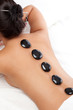 pretty woman receiving a therapy with hot stones pretty woman receiving a therapy with hot stones