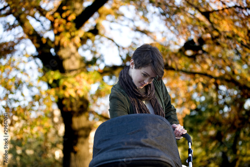 Photo: A mother standing with a buggy in the park A mother standing with a buggy in the park