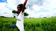 Excited young woman in field with a windmill in background