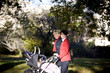 Two mothers pushing their buggies in the park, smiling