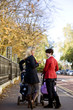 Two mothers standing with buggies, talking