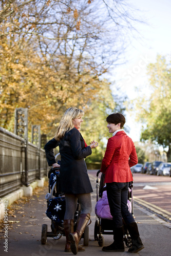 Photo: Two mothers standing with buggies, talking Two mothers standing with buggies, talking