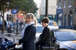 Two mothers pushing their buggies in the street