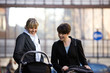 Two mothers pushing their buggies in the street