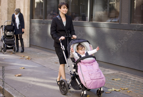 Photo: Two mothers pushing their buggies in the street Two mothers pushing their buggies in the street
