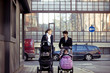Two mothers pushing their buggies in the street