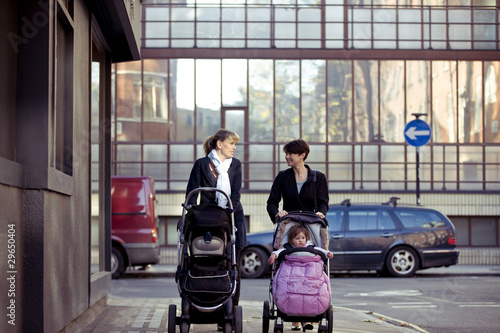 Photo: Two mothers pushing their buggies in the street Two mothers pushing their buggies in the street