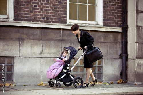 Photo: A mother pushing a buggy in the street A mother pushing a buggy in the street