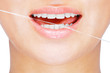 Foto: Young caucasian woman flossing her teeth , white background Young caucasian woman flossing her teeth , white background