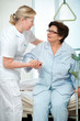 Nurse helps a patient to get up in hospital Nurse helps a patient to get up in hospital
