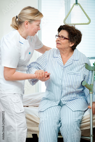 Foto: Nurse helps a patient to get up in hospital Nurse helps a patient to get up in hospital