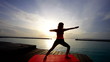 woman practices yoga at sunset