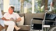 Elderly man talking to someone on his sofa