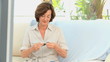 Mature woman knitting in the living room