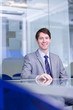 Smiling businessman sitting at conference table