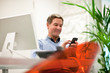 Photo: Businessman text messaging in office Businessman text messaging in office