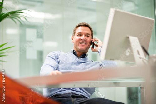 Photo: Businessman on the phone in office Businessman on the phone in office