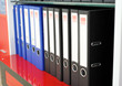 Colored folders are on a shelf in a row