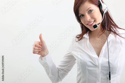 Photo: young woman with headset and thumb up young woman with headset and thumb up