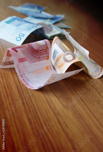 Photo: euro and different money on wooden table euro and different money on wooden table