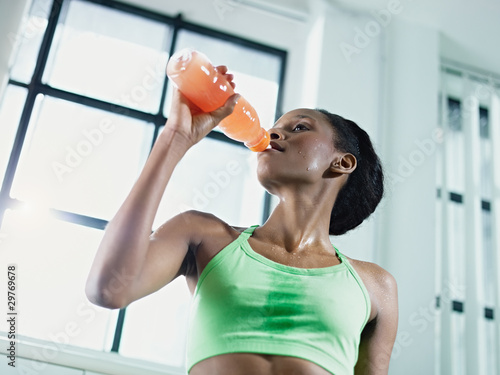 Photo: african woman in gym drinking energy drink african woman in gym drinking energy drink