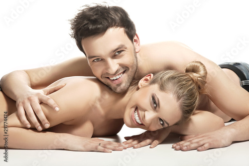 Photo: Beautiful young couple lying on the bed Beautiful young couple lying on the bed