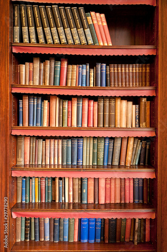 Photo: Old bookshelf with rows of books in ancient library Old bookshelf with rows of books in ancient library