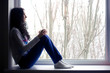 Lonely girl near the window with cup Lonely girl near the window with cup