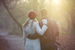A young couple pushing a stroller in the park, rear view