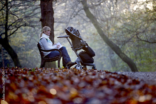 Photo: A young mother sitting on a bench, writing in a journal A young mother sitting on a bench, writing in a journal