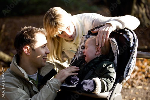 Photo: A young couple comforting their son A young couple comforting their son