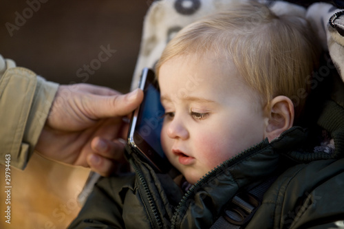 Photo: A father passing his iphone on to his son A father passing his iphone on to his son