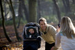 A mother photographing her partner and child in the park
