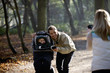 A mother photographing her partner and child in the park