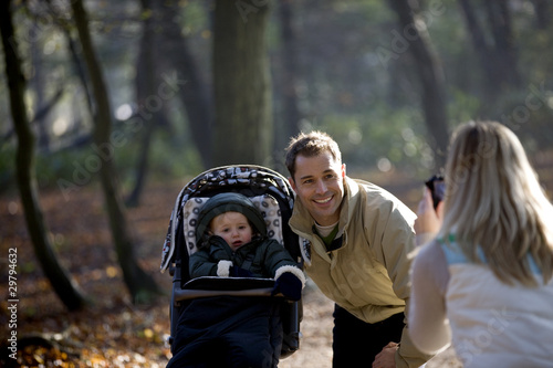 Photo: A mother photographing her partner and child in the park A mother photographing her partner and child in the park