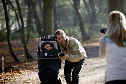 Photo: A mother photographing her partner and child in the park A mother photographing her partner and child in the park
