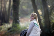 A young mother pushing a stroller in the park, smiling