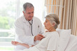 Foto: Senior doctor taking the heartbeat of his patient Senior doctor taking the heartbeat of his patient