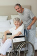 Retired woman in her wheelchair with her husband Retired woman in her wheelchair with her husband